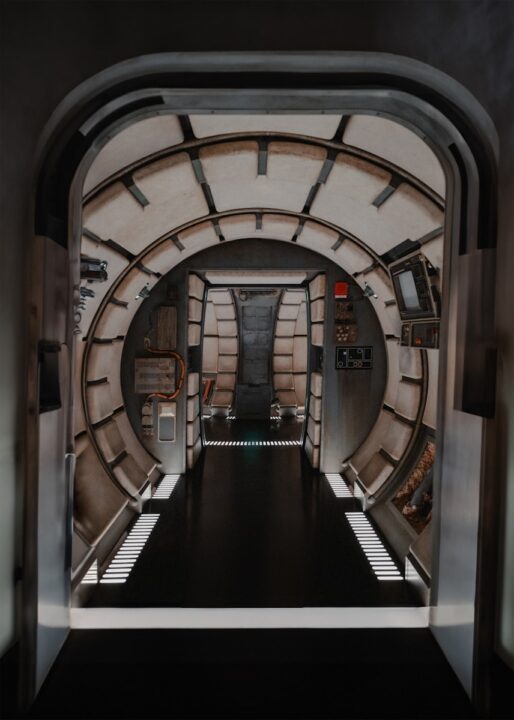 a hallway in a sci - fi style building with a door leading to another room